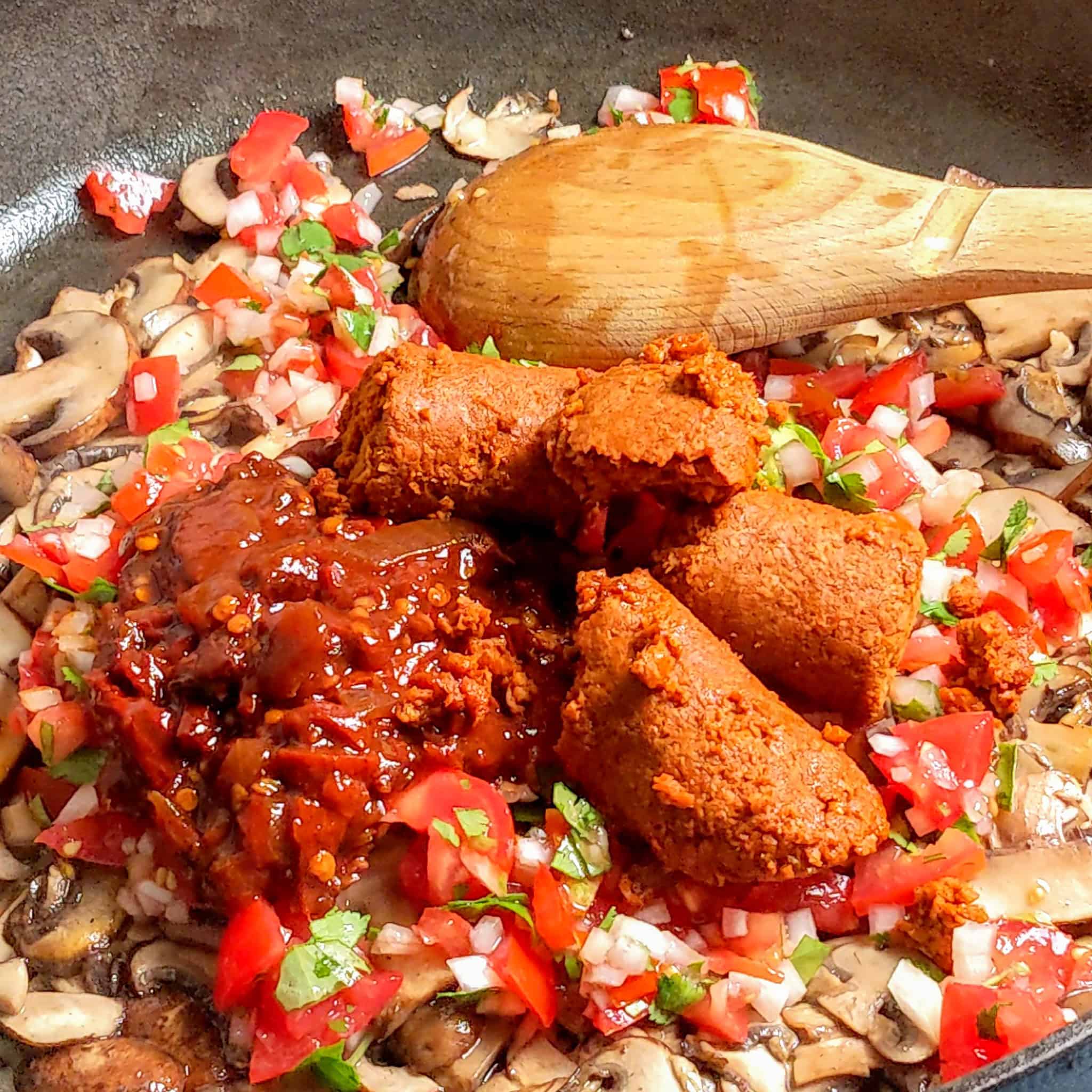 chipotle in adobo and soy chorizo added to the sauted mushroom mixture in a cast iron skillet.